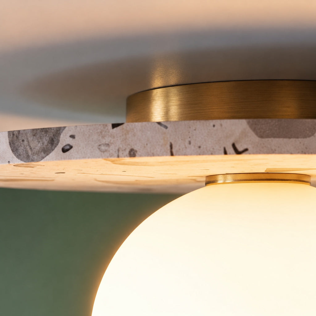 Moderne terrazzo-loftlampe med plan montering, kugleformet glasskærm og kobberdetaljer til stemningsbelysning | ribuella