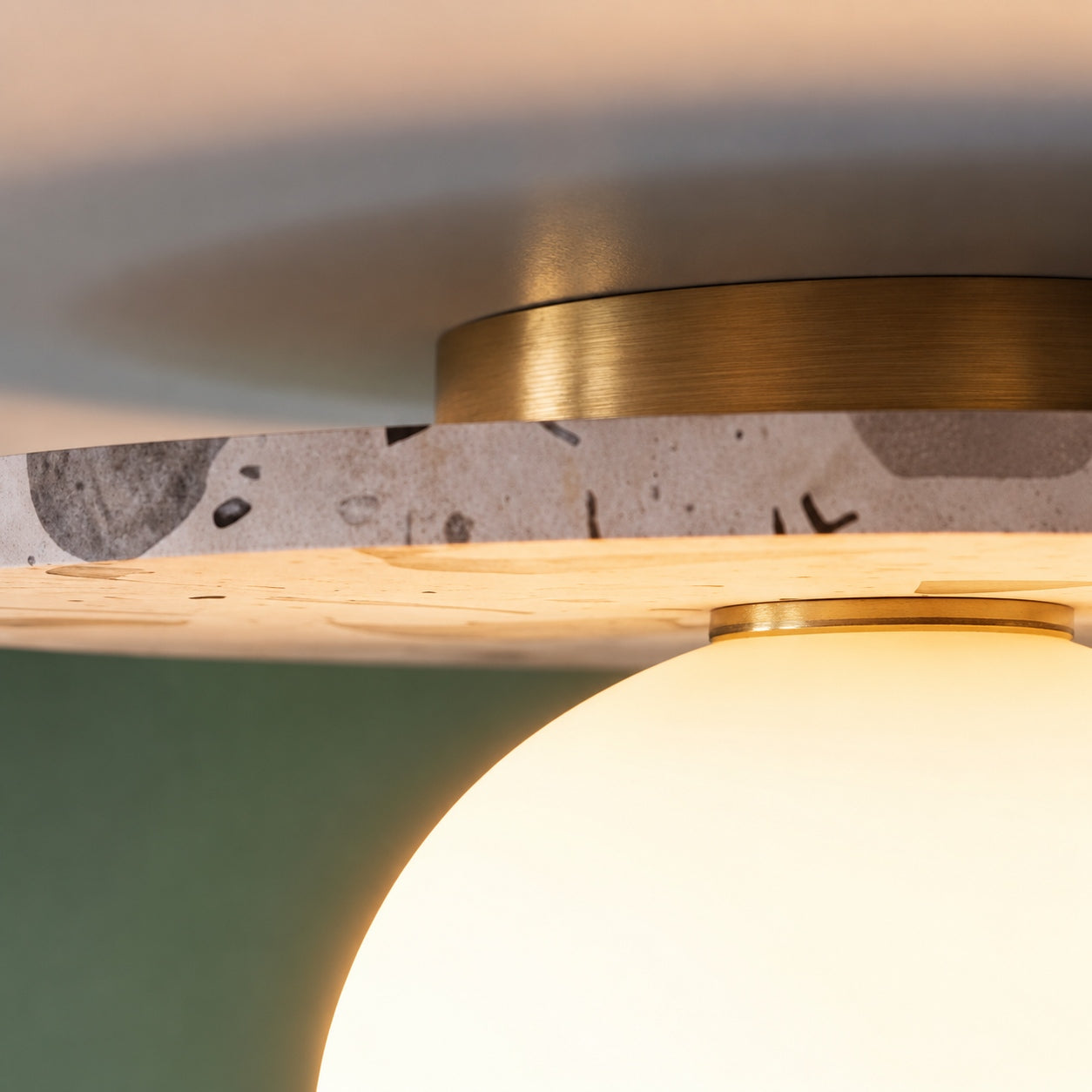 Moderne terrazzo-loftlampe med plan montering, kugleformet glasskærm og kobberdetaljer til stemningsbelysning | ribuella