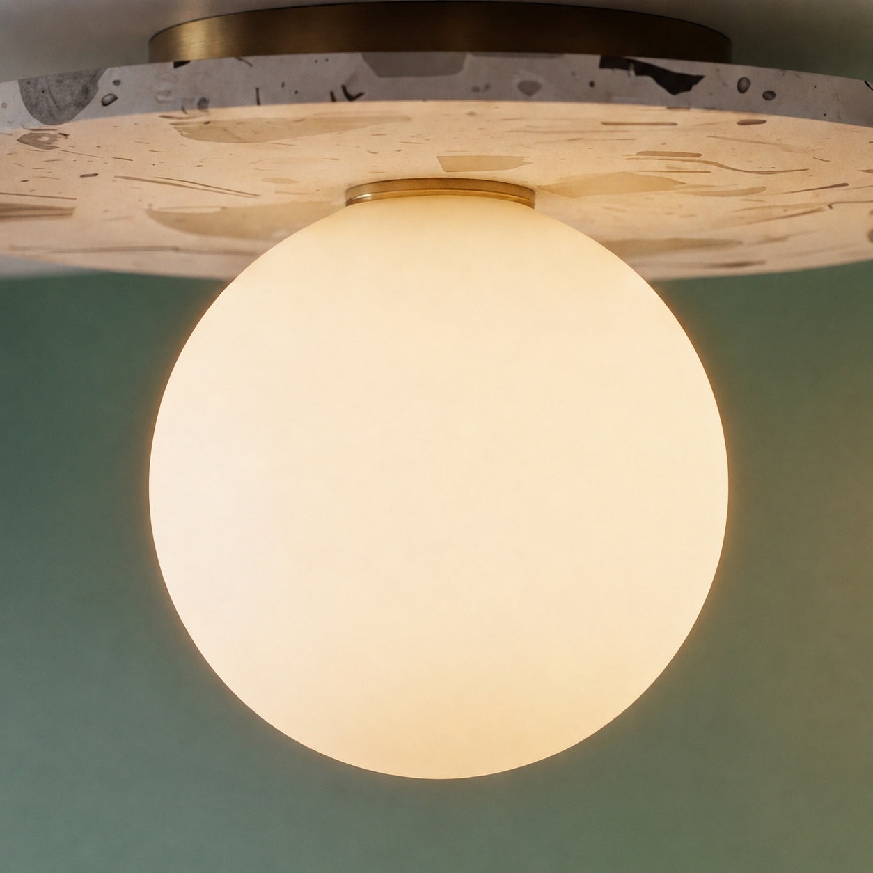 Moderne terrazzo-loftlampe med plan montering, kugleformet glasskærm og kobberdetaljer til stemningsbelysning | ribuella