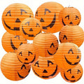 12 papierowych wiszących lampionów w kształcie dyni, z klasycznymi halloweenowymi twarzami Jack-o’-lantern