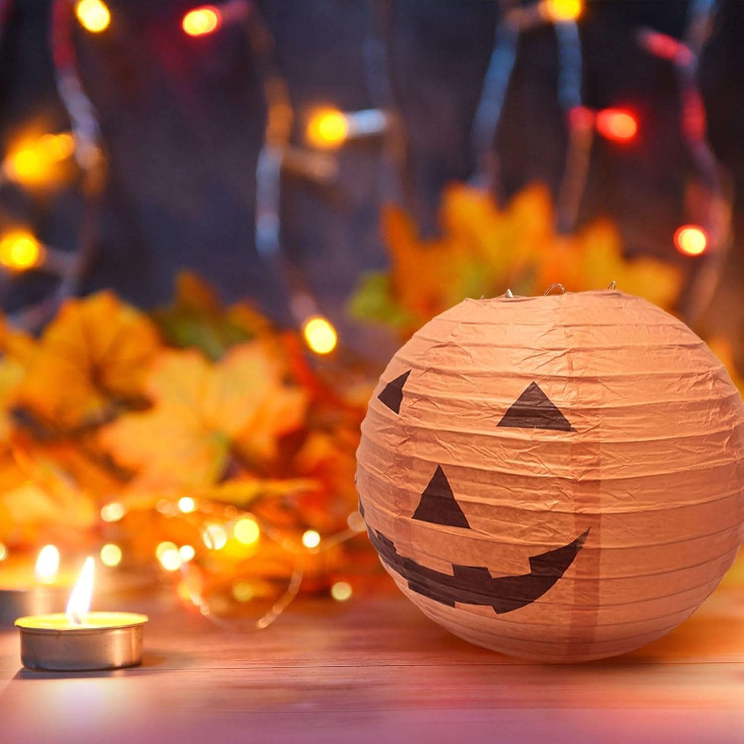 12 papierowych wiszących lampionów w kształcie dyni, z klasycznymi halloweenowymi twarzami Jack-o’-lantern