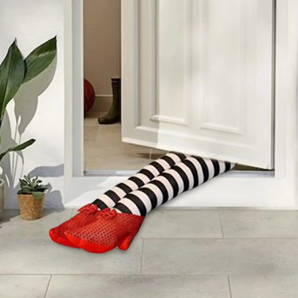 Halloween boszorkányláb-ajtókitámasztó, csíkos plüsskivitelben, piros flitteres cipőkkel